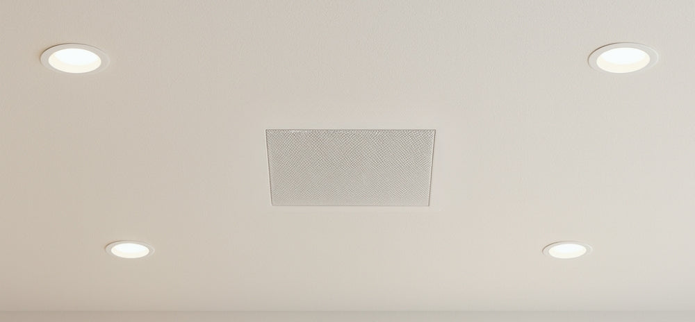 Flush-mounted Theory speaker in ceiling surrounded by recessed lights – minimal architectural design.