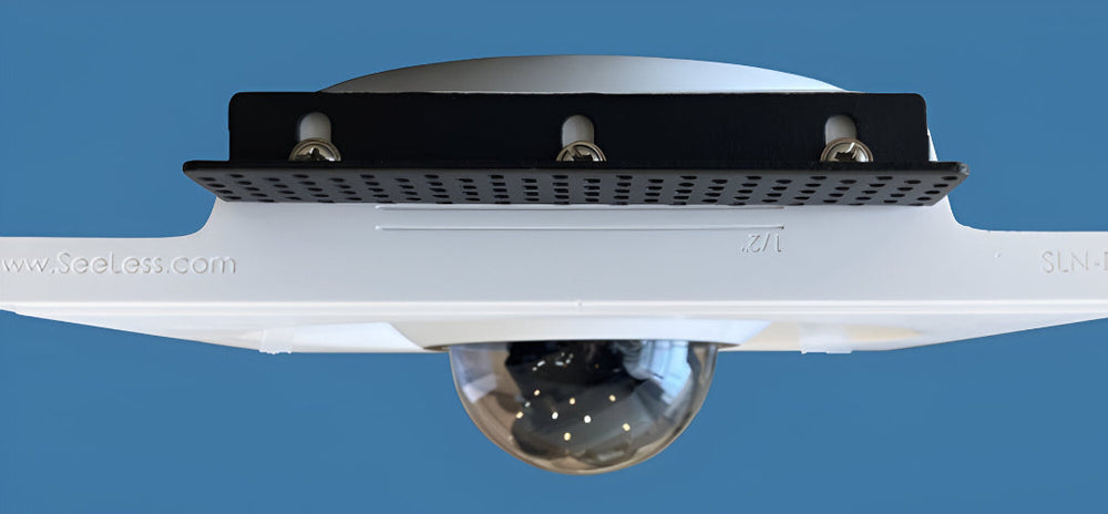 Verkada security camera recessed into a SeeLess white ceiling mount with black bracket, shown against a blue background.