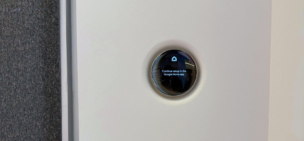 Flush-mounted Nest smart thermostat installed in wall with minimalist design.