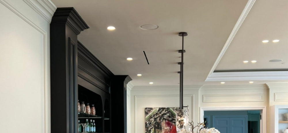 Araknis 820 wireless access point recessed into a SeeLess ceiling mount (model SLW-RAPL2-500), seamlessly integrated within an elegant interior featuring crown moulding and recessed lighting.