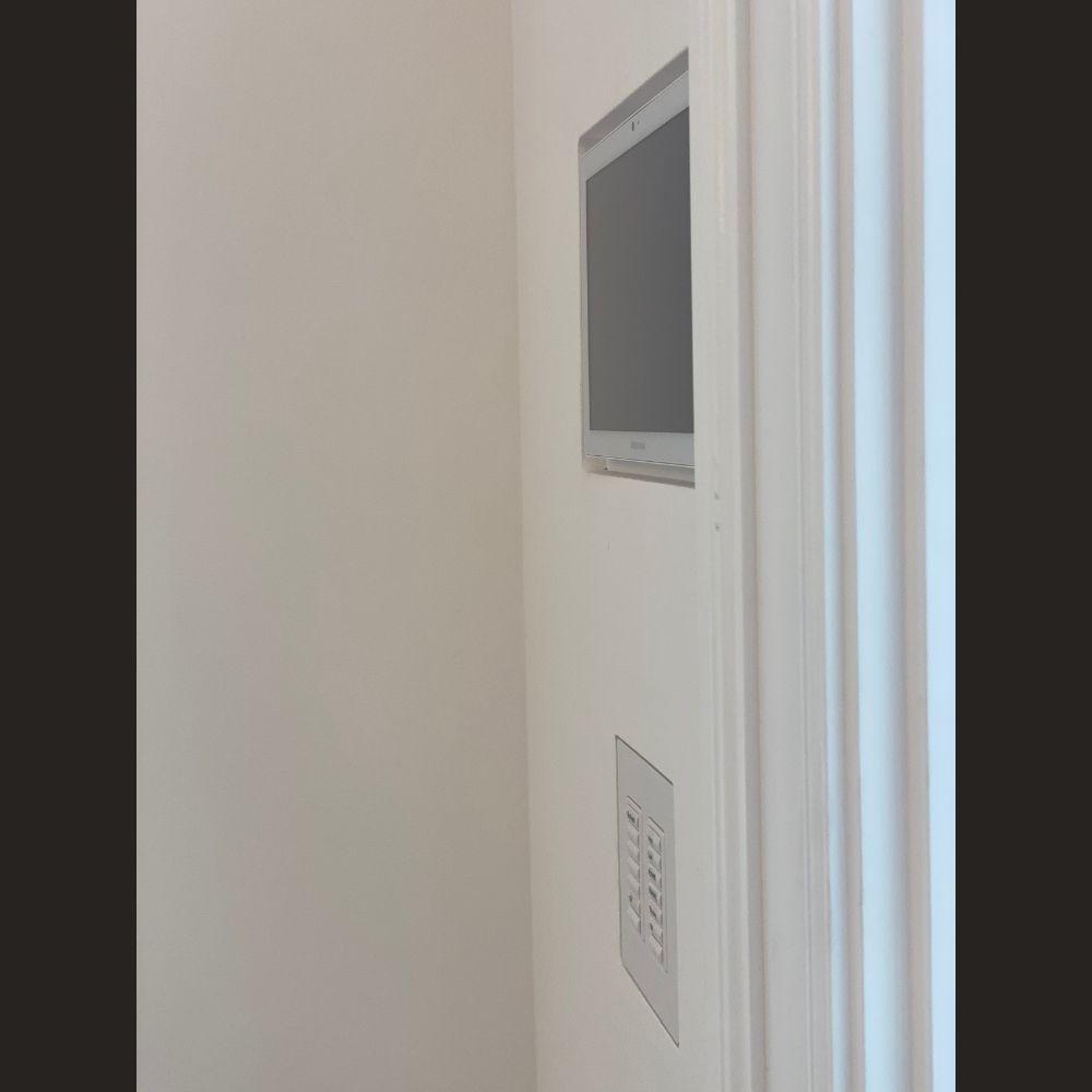 SeeLess SLA‑TPCT7‑375 with Crestron 7″ 70 Series touch panel — trimless design, painted gypsum mount.