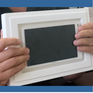 Close‑up of Crestron 7″ panel fitted into SLA‑TPCT7‑375 gypsum mount — exact two‑gang opening and precision fit.