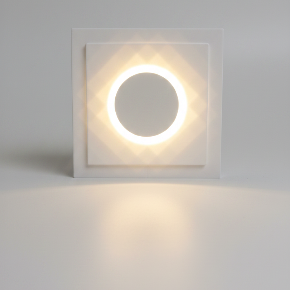 A round white recessed light fixture with a glowing circular LED ring in the center, shown on a tabletop.