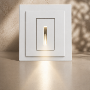 White rectangular SeeLess step light SL-3005-06 with warm 1/16" reveal glow, styled against a travertine wall with soft shadow detailing