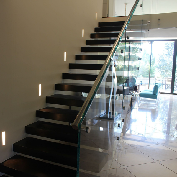 Multiple SeeLess 6-inch step lights installed along a stairway wall, providing soft, indirect illumination for safety and architectural appeal