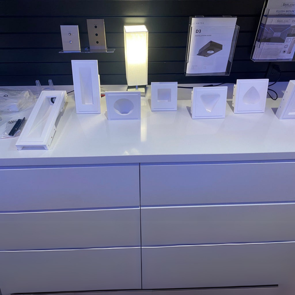 Display of gypsum step light flush mounts variety on a white countertop with a dark background
